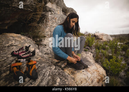 Femme portant des chaussures de sport sur rock Banque D'Images