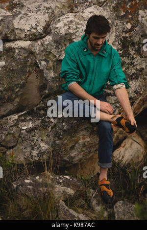Homme portant des chaussures de sport pendant l'alpinisme Banque D'Images