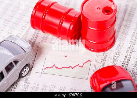 Diagramme avec une courbe ascendante entouré par les voitures et les barils de pétrole. Banque D'Images