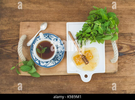 Tasse de tisane à la menthe fraîche et le miel sur plateau en bois rustique sur l'arrière-plan. Vue d'en haut. Banque D'Images