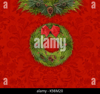 Belle couronne de Noël traditionnels dans le cadre d'une guirlande de pommes de pin rouge contre le papier peint damassé Banque D'Images