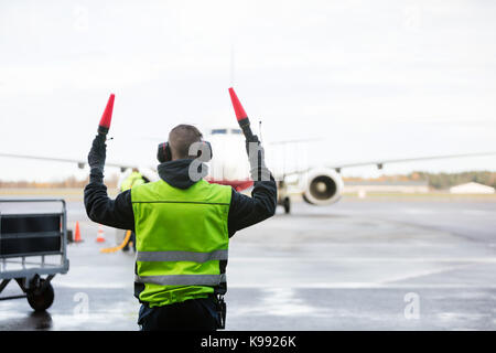 Le personnel au sol à la signalisation d'avion Banque D'Images