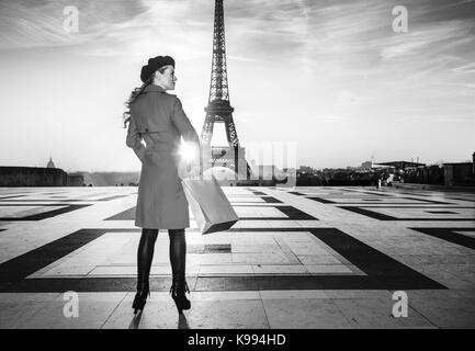 Brillante dans Paris. vu de dos touristiques à la mode femme en robe rouge à Paris, France avec panier à côté Banque D'Images