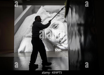 Un travailleur nettoie un mur dans les salles d'exposition couvert de toile jaune au cours d'une conférence de presse de l'exposition 'je suis un problème" au musée d'art moderne "mk 2" à l'taunusturm à Francfort/Main, Allemagne, 22 septembre 2017. mondtag étapes une exposition avec un mélange d'arts visuels et théâtre, ouvert du 23 septembre 2017 jusqu'au 18 février 2018. photo : Frank rumpenhorst/dpa Banque D'Images