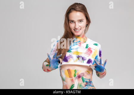 Jeune femme enduite de peinture multicolore. Banque D'Images