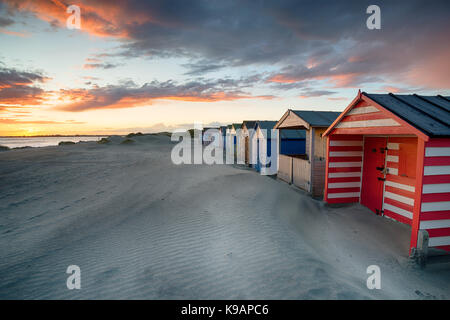 Cabines de plage au coucher du soleil spectaculaire à West Wittering sur la côte du Sussex Banque D'Images