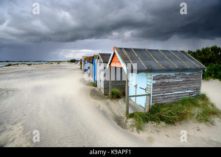 Cabines de plage sous un ciel d'orage spectaculaire à West Wittering sur la côte du Sussex de l'Ouest Banque D'Images