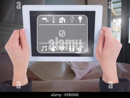 Digital composite of Hand holding tablet avec interface smart home à la maison Banque D'Images