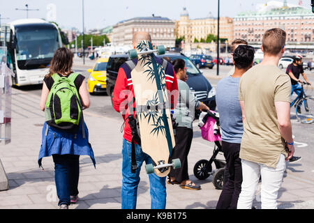 La vie urbaine. Les Touristes avec sac à dos et longboard en plein air Banque D'Images