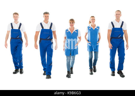 Portrait de certains hommes et femmes concierges walking in row against white background Banque D'Images