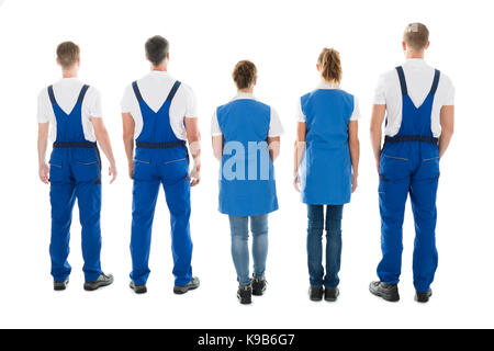 Vue arrière sur toute la longueur de l'homme et de la femme debout dans la rangée contre concierges fond blanc Banque D'Images