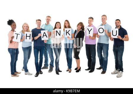 Portrait de creative business people holding merci sign against white background Banque D'Images