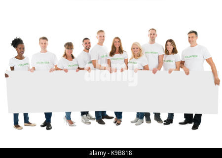 Portrait de certains bénévoles holding blank billboard against white background Banque D'Images