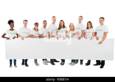 Portrait de certains bénévoles holding blank billboard against white background Banque D'Images