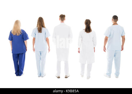 Vue arrière sur toute la longueur des professionnels médicaux standing against white background Banque D'Images