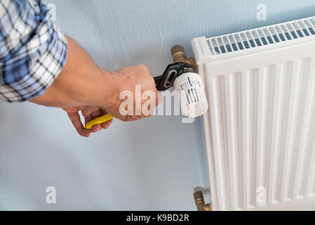 Close-up of male plombier radiateur fixation à l'aide d'une clé Banque D'Images