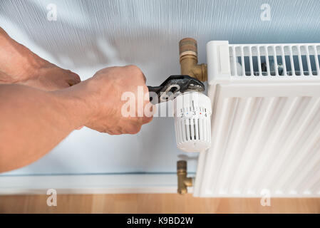 Close-up of male plombier radiateur fixation à l'aide d'une clé Banque D'Images