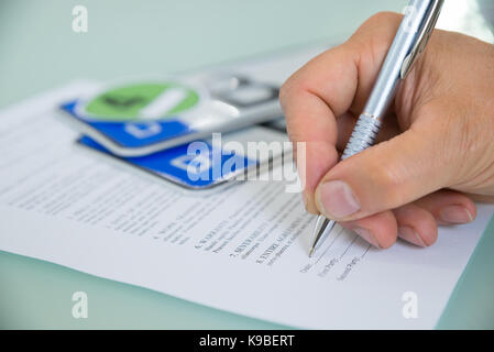 Close-up d'une part remplir formulaire Contrat de vente de voiture avec plaque d'immatriculation du véhicule sur 24. contrat papier contient du texte Banque D'Images