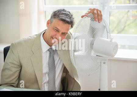 Portrait of a happy man à côté de la soufflante dans office Banque D'Images