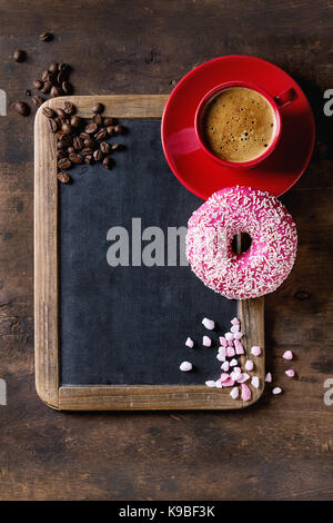 Tableau vintage vide, rose vitrage beigne, le sucre, les grains de café et tasse de café noir rouge sur fond de bois ancien. Vue de dessus avec l'espace pour le texte. Banque D'Images