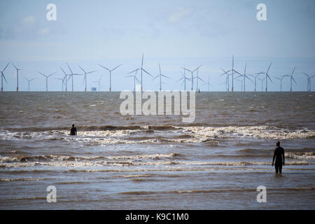 Anthony gormleys un autre endroit sur Crosby Beach partie du crosby coastal park liverpool avec le parc éolien dans l'arrière-plan Banque D'Images