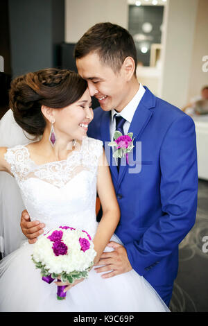 Couple charmant mariée et le marié dans le hall de rire et sourire sincèrement portrait positif. sincères sentiments, émotions fortes. mariage bouquet dans les mains, tout dans un schéma de couleurs. Banque D'Images