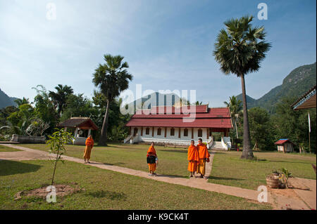 Quatre moines bouddhistes se tiennent à l'extérieur leur temple dans le petit village rural de Muang Ngoi, au nord-est de l'Laos Banque D'Images