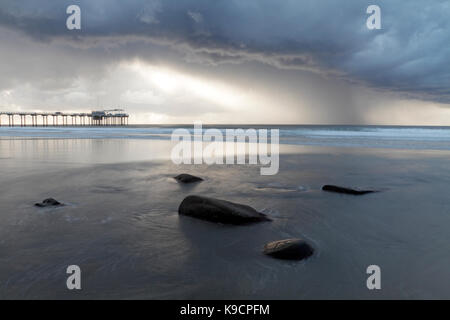 Jetée de Scripps, La Jolla, San Diego, vue pendant un orage de la plage de rochers en premier plan et dramatique de l'éclairage. Banque D'Images