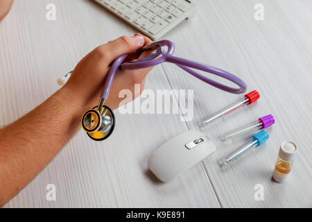 Les mains du médecin à la table tient dans les mains d'un endoscope Banque D'Images