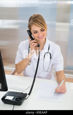 Portrait of young woman talking on telephone Banque D'Images