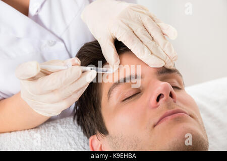 Jeune homme ayant un traitement au Botox beauty clinic Banque D'Images