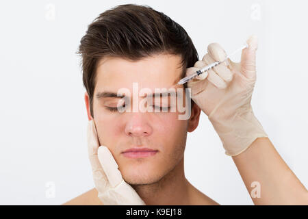 Close-up de l'injection avec seringue mains personne botox pour le traitement visage Banque D'Images