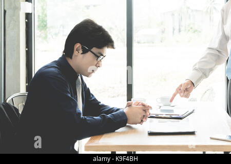 Gestionnaire d'affaires de l'Asie à l'origine employé en pointant vers lui pour l'erreur le travail, stress sentiment dans office cafe Banque D'Images