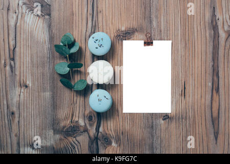 Beige et bleu macarons et maquette carte postale vierge sur fond de bois Banque D'Images