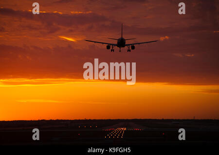 Un avion à l'atterrissage au coucher du soleil Banque D'Images