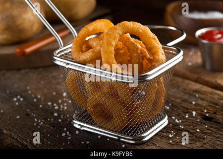 Délicieux croustillant des oignons dans un panier de friture. Banque D'Images