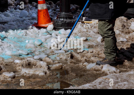 Le chantier de nettoyage de neige. l'homme dans un manteau et bottes, tenant une pelle en plastique avec de la neige, les travailleurs de la route de la neige de balayage en hiver, nettoyage de route s Banque D'Images