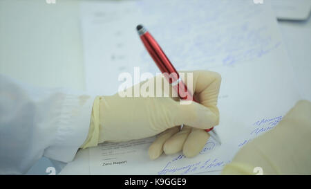 Portrait médecin écrit sur papier à la clinique. close up of patient et médecin en prenant des notes. médecin écrit une prescription. physiothérapeute writing on clipboard in clinique. femme médecin écrit une prescription. un scientifique prend des notes sur un ordinateur portable. la science et de la médecine Banque D'Images