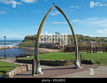 L'abbaye de Whitby vu de loin sous un ciel bleu avec des taches de nuage blanc à travers une arche faite à partir d'une mâchoire de baleine Banque D'Images