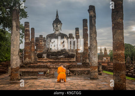Monk priant, à Wat Mahathe, Parc historique de Sukhothai, Sukhothai, Thaïlande Banque D'Images