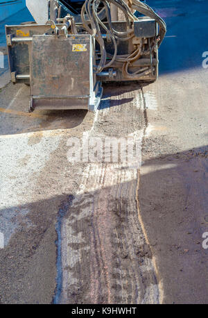 Déposer les mini-pilote travailleur porté pendant la réparation d'asphalte travaux routiers Banque D'Images