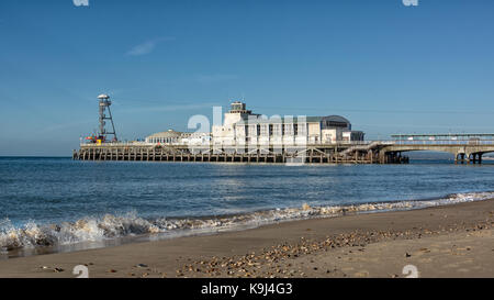 La jetée de Bournemouth à partir d'un angle faible montrant les vagues sur le rivage et d'une plage déserte Banque D'Images