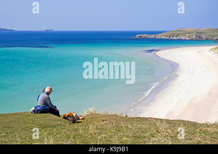 Deux femmes d'âge moyen avec dog having picnic sur le bord de la falaise surplombant la mer calme d'herbe et de sable blanc, la plage de Balnakeil Bay, Sutherland, UK Banque D'Images