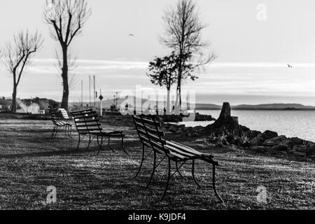 Assis sur des bancs d'un lac Banque D'Images