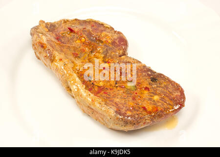 Steak de boeuf avec la marinade en plaque blanche Banque D'Images