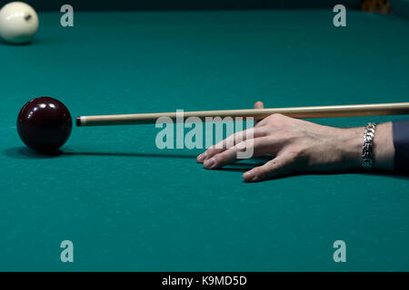 Un joueur du bras avec un repère sur une table de billard prêt à temps une balle Banque D'Images