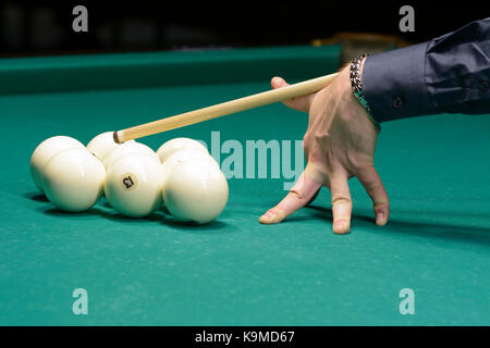 Un joueur du bras avec un repère sur une table de billard prêt à temps une balle Banque D'Images