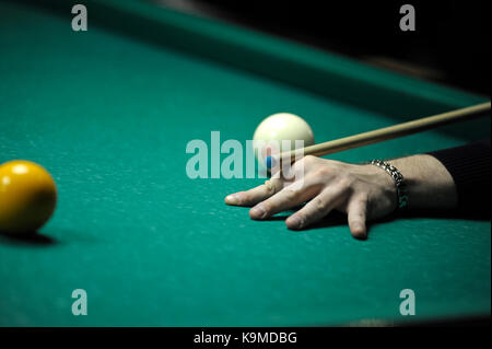 Un joueur du bras avec un repère sur une table de billard prêt à temps une balle Banque D'Images