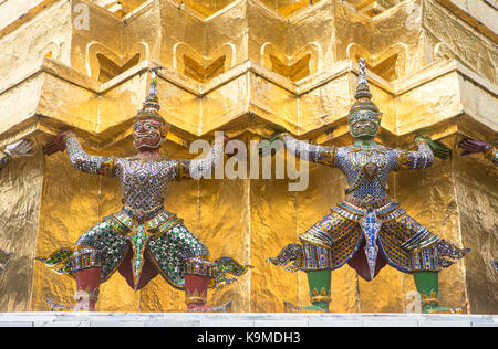 Statues de démons sur un Chedi d'or, au temple du Bouddha d'Émeraude Wat Phra Kaeo, Grand Palais Royal, Bangkok, Thaïlande Banque D'Images