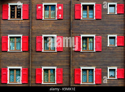 Fenêtres avec volets rouges sur maison de bois, saas-fee, Valais, Suisse Banque D'Images